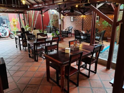 un restaurante con mesas de madera y sillas en un patio en Soben Cafe Guesthouse & Restaurant en Siem Reap