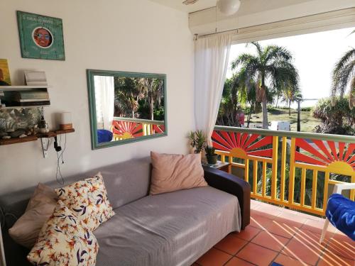 a living room with a couch and a balcony at CARIBBEAN HOME apt 343 Domaine Anse des Rochers in Saint-François