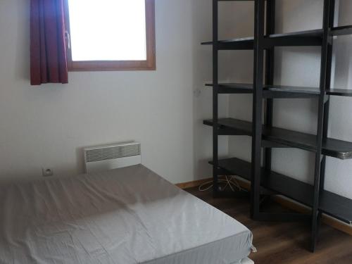 une chambre avec un lit et une étagère dans l'établissement Charmant Appartement 2 Pièces pour 4 Personnes avec Balcon à Proximité des Pistes - Orcières Merlette - FR-1-636-121, à Orcières