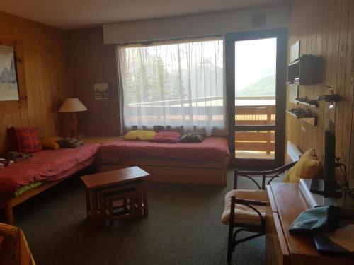 une chambre d'hôtel avec deux lits et une fenêtre dans l'établissement Appartement cosy 2 pièces, 6 pers, 43m², centre-station à Merlette, prox. pistes & commerces - FR-1-636-124, à Orcières