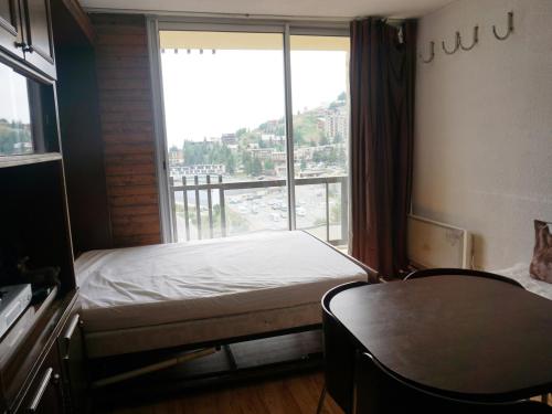 une chambre avec un lit et une grande fenêtre dans l'établissement Studio cabine 23m² pour 4 personnes proche des pistes - FR-1-636-127, à Orcières