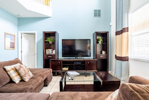 a living room with a couch and a tv at Orlando Vacation Rental Homes in Kissimmee