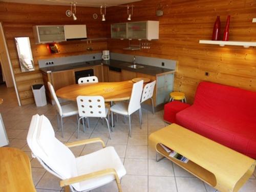 - une cuisine et une salle à manger avec une table et un canapé rouge dans l'établissement Charmant 3 pièces, animaux acceptés, 700m des pistes, 6 personnes, linge de lit inclus hiver - FR-1-636-145, à Orcières