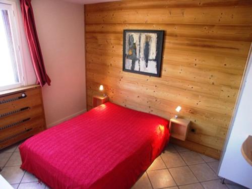 a bedroom with a red bed in a wooden wall at Charmant 3 pièces, animaux acceptés, 700m des pistes, 6 personnes, linge de lit inclus hiver - FR-1-636-145 in Orcières
