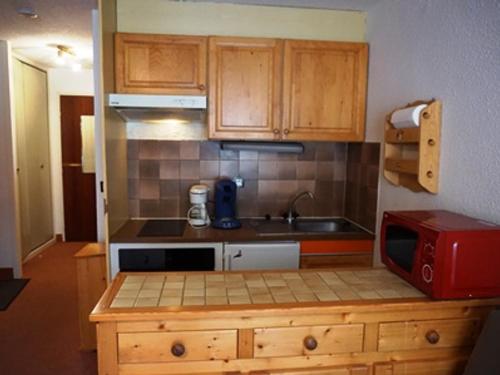 une petite cuisine avec un évier et un micro-ondes dans l'établissement Studio 4 pers, proche pistes et commerces, animaux acceptés - FR-1-636-167, à Orcières