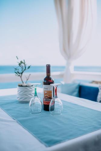 a bottle of wine and two vases on a table at Villa Sea Breeze in Karpathos