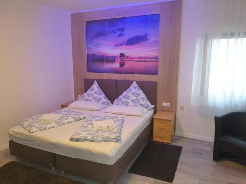 ein Schlafzimmer mit 2 Betten und einem Gemälde an der Wand in der Unterkunft Restaurant & Hotel Exquisite in Bobenheim am Berg