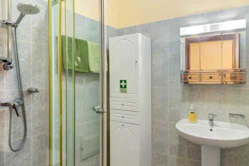 y baño con ducha y lavamanos. en Palheiro Residence Vista Mar, en Funchal