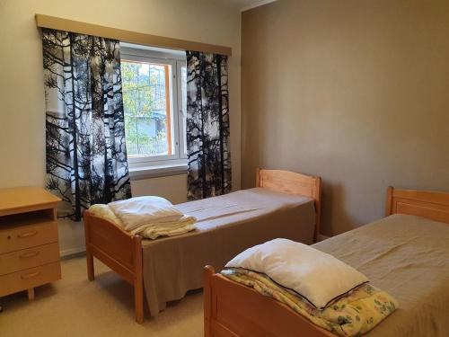 - une chambre avec 2 lits et une fenêtre dans l'établissement Hostelli Kotiranta, à Lieksa