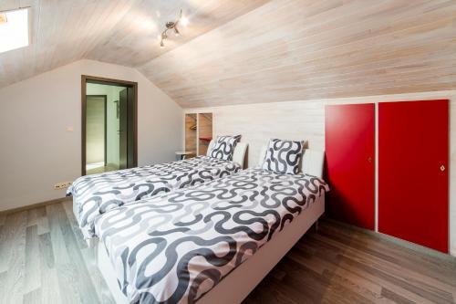 a bedroom with two beds and a red cabinet at Le Boca in Les Waleffes