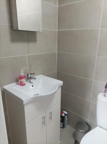 a bathroom with a white sink and a toilet at Private Studio on Finchley Road in London