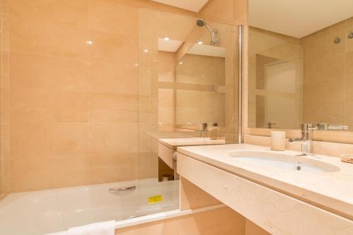 y baño con bañera, lavabo y espejo. en 2214-Modern apt with private beach, en Estepona