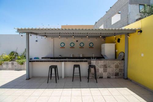 a outdoor kitchen with two stools and a bar at Nuevos departamentos (6) centro histórico a 200 mta malecón in La Paz