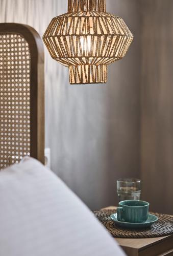 a table with a plate and a chandelier next to a bed at Villa Gallis in Pollonia
