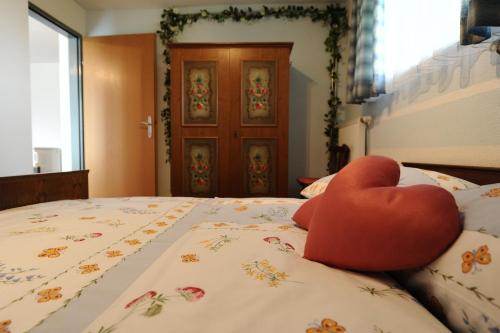 a red heart pillow sitting on top of a bed at Frühstückspension Lach in Eberndorf