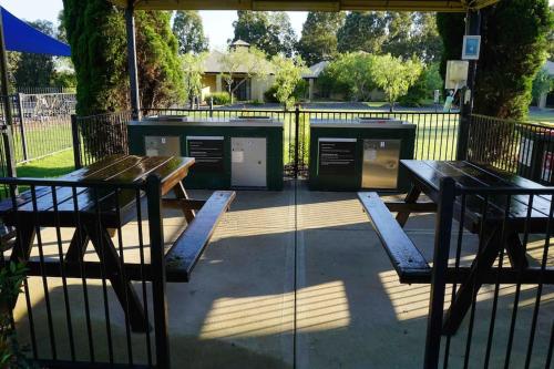 a picnic table and benches next to a fence at Newly Renovated Central Private Studio in Pokolbin