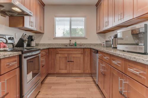 a kitchen with wooden cabinets and stainless steel appliances at @ Marbella Lane - Boho 'n Sleek Rtreat Pool Tble in Union City
