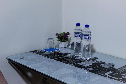 a table with two bottles of water and flowers on it at Casa Leon 5 min away from the Airport in Lima