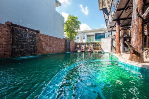 a swimming pool with green water in a building at Nice Villa Resort in Songkhla