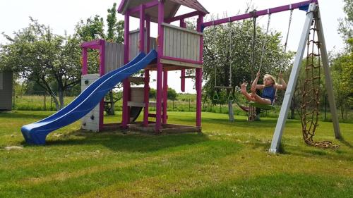 a woman swinging on a slide on a playground at Sielankowo Trzęsacz in Trzęsacz
