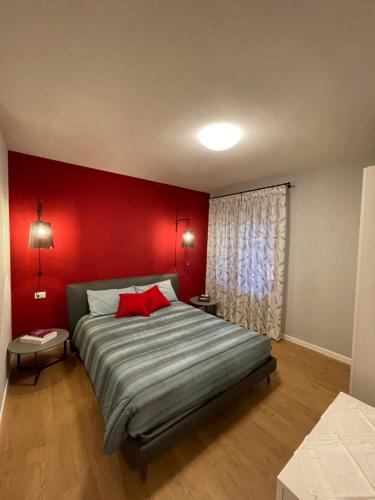 a bedroom with a bed with a red wall at AZIENDA AGRICOLA MOSCHIONI in Cividale del Friuli