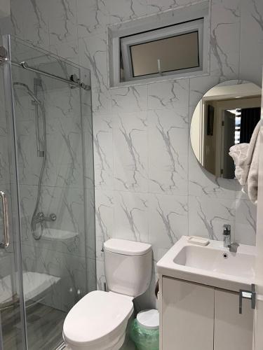 a bathroom with a toilet and a sink and a shower at Odyssey Exquisite @ Charlemont in Kingston