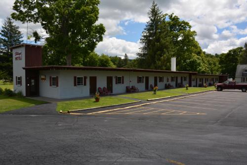 a building with a fire hydrant in a parking lot at The Village Motel in Richfield Springs