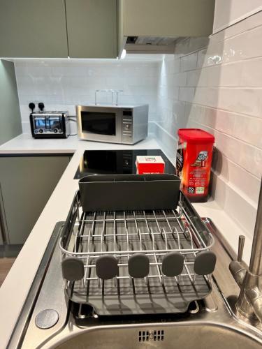 a kitchen with a sink and a stove top oven at Lovely Super Luxury One Bed Apartment 216 in Luton