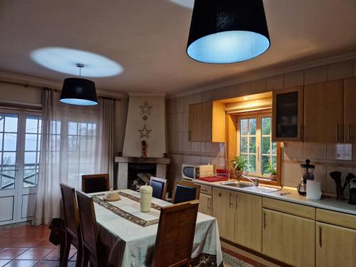 cocina con mesa con sillas y 2 luces en Quinta de S. Vicente 317, en Vila Nova de Famalicão