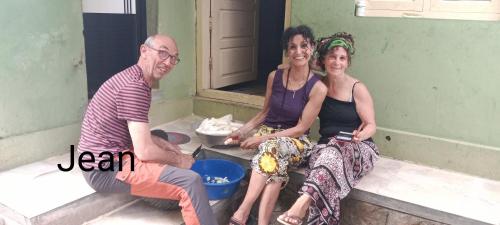 three people sitting on the steps of a house at Maliyeckal Homestay in Munnar