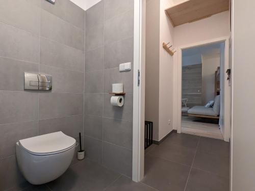 a bathroom with a toilet and a view of a bedroom at JASMIN HOME Apartments in Vítkovice