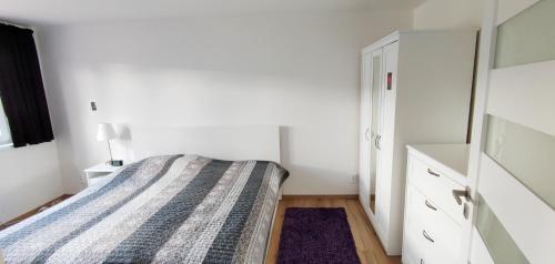 niewielka sypialnia z łóżkiem i komodą w obiekcie Apartmán Pod Ještědem w mieście Liberec