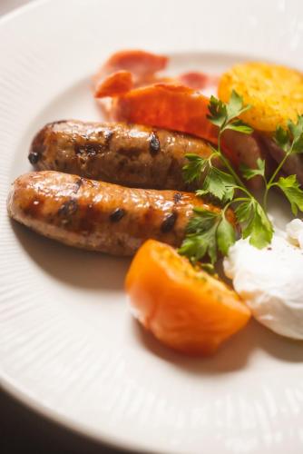 two sausages and eggs on a white plate with food at The Pied Bull in Chester