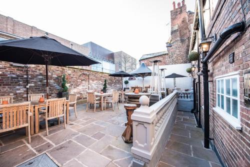 a patio with tables and chairs and an umbrella at The Pied Bull in Chester