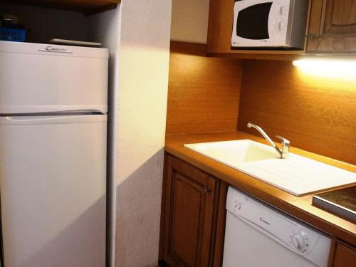 une cuisine avec un réfrigérateur blanc et un évier dans l'établissement Duplex cosy 60 m², 7-8 pers, proche pistes et commerces, parking inclus, animaux acceptés. - FR-1-636-6, à Orcières