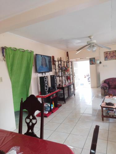 a living room with a couch and a ceiling fan at Tina's Guest House in Ocho Rios