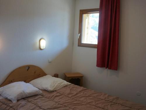 - une chambre avec un lit et une fenêtre avec un rideau rouge dans l'établissement Appartement 2P cabine, 6 pers, animaux acceptés, parking inclus - FR-1-636-43, à Orcières