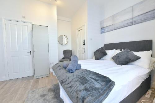 ein Schlafzimmer mit einem großen weißen Bett und einem Stuhl in der Unterkunft Central London Luxury Studios Fulham Close to Underground Newly Refurbished in London