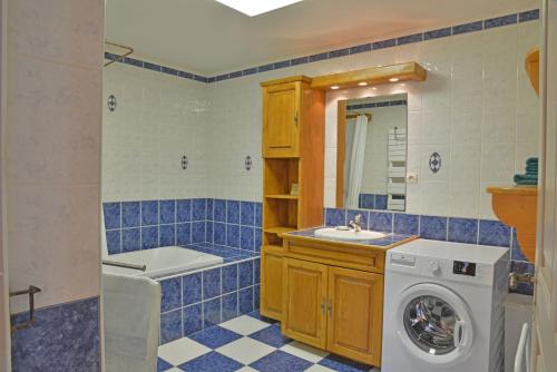 een blauwe betegelde badkamer met een wasmachine bij Appartement dans chalet 5 chambres 130 m2 centre village in Montriond