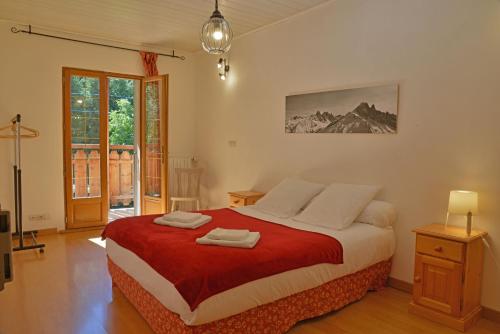 a bedroom with a large bed with a red blanket at Appartement dans chalet 5 chambres 130 m2 centre village in Montriond