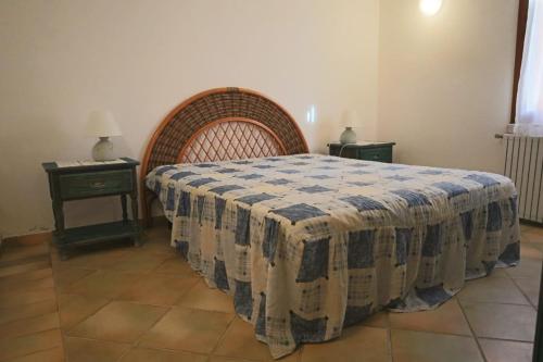 a bedroom with a bed with a blue and white blanket at Borgo Le Logge in Budoni