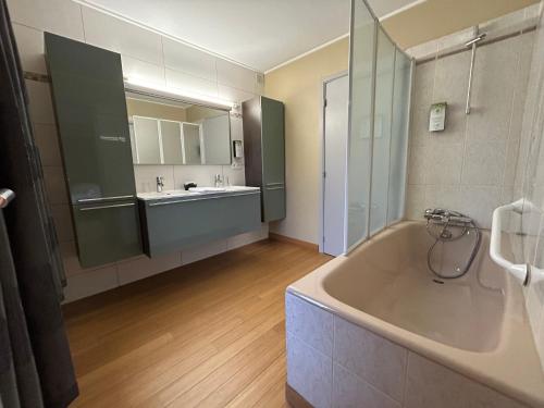 a large bathroom with a tub and a sink at Race & Rooms in Francorchamps