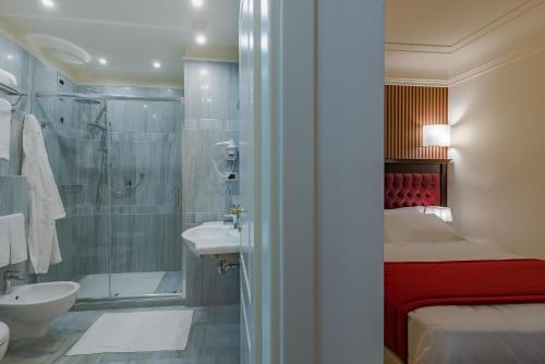 uma casa de banho com um chuveiro, uma cama e um lavatório. em La Paloma Blanca Hotel em Sciacca