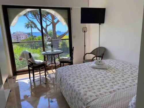 - une chambre avec un lit et une fenêtre avec une table et des chaises dans l'établissement The Sun Paradise Dream, à Cannes