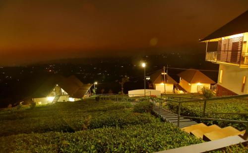 a house on a hill at night with lights at 10 Degrees North By Avni Holidays in Idukki