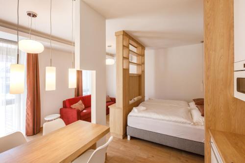a small apartment with a bed and a dining room at La Bella Centrum apartmanok Piros/Sárga in Hévíz
