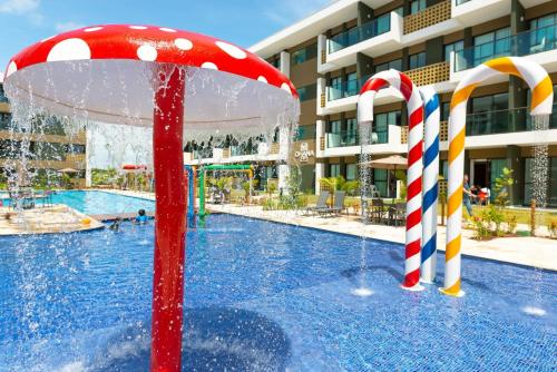 a pool with a water park with candy canes at Mana Beach Experience Muro Alto por Brevelar in Porto De Galinhas