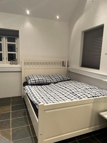 uma cama branca num quarto com duas janelas em Auszeit im Grünen em Fårvang