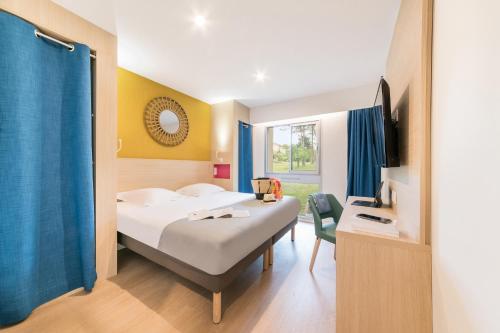 a hotel room with two beds and a tv at Belambra Clubs L'Isle Sur La Sorgue - Domaine De Mousquety in LʼIsle-sur-la-Sorgue