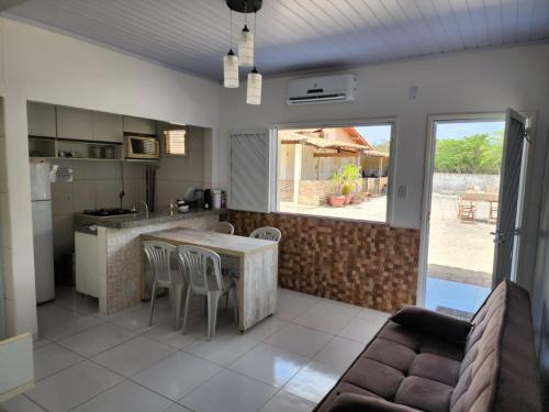 een keuken en een woonkamer met een tafel en stoelen bij BARREIRINHAS CHALÉ 12 PORTO DOS LENÇÓIS in Barreirinhas